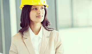 Indian business women with construction hat looking into the distance